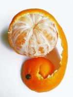 mandarin with half peeled skin on a white background photo