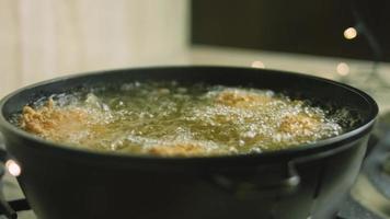 frite as pernas e asas de frango em óleo. a carne tem uma camada de farinha com especiarias video