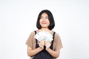 sosteniendo un nuevo billete de indonesia de una hermosa mujer asiática aislada de fondo blanco foto