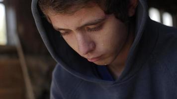 verdrietig jong Mens, tiener- jongen zittend alleen, huilen met tranen Aan zijn gezicht video
