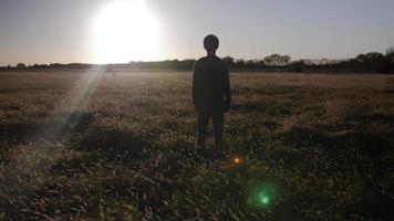 Young Man, Teenage Boy Standing In A Field Watching The Sunset Alone, Silhouette video