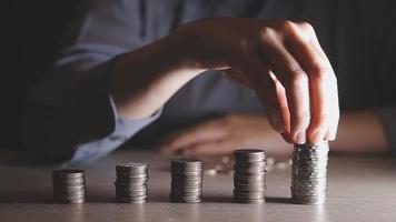 businessman holding coins putting in glass with using calculator to calculate concept saving money for finance accounting, Business, finance, investment, Financial planning. video