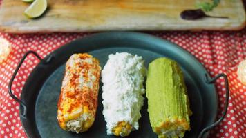 elote de maíz mexicano en tres formas. prensado con queso, guacamole y granada. bandera maxicana video