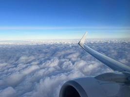 View from the airplane window. Beautiful cloudscape with blue sky. Wonderful panorama above white clouds as seen through window of an plane. Traveling by air concept photo