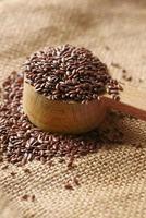 close up of flax seeds on wooden spoon on table photo