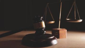 Justice and law concept.Male judge in a courtroom with the gavel, working with, computer and docking keyboard, eyeglasses, on table in morning light video