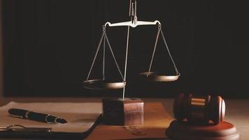 Justice and law concept.Male judge in a courtroom with the gavel, working with, computer and docking keyboard, eyeglasses, on table in morning light video