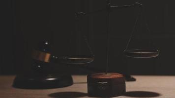 Justice and law concept.Male judge in a courtroom with the gavel, working with, computer and docking keyboard, eyeglasses, on table in morning light video