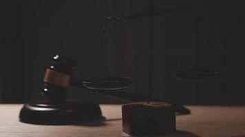 Justice and law concept.Male judge in a courtroom with the gavel, working with, computer and docking keyboard, eyeglasses, on table in morning light video