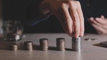 businessman holding coins putting in glass with using calculator to calculate concept saving money for finance accounting, Business, finance, investment, Financial planning. video