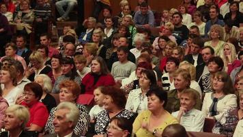 la foule est assise et écoute lors d'un spectacle video