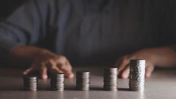 businessman holding coins putting in glass with using calculator to calculate concept saving money for finance accounting, Business, finance, investment, Financial planning. video