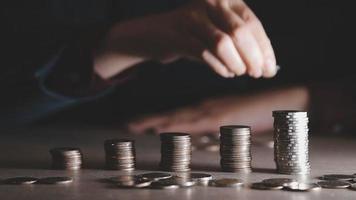 businessman holding coins putting in glass with using calculator to calculate concept saving money for finance accounting, Business, finance, investment, Financial planning. video