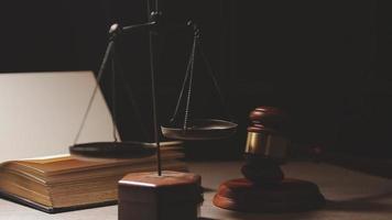 Justice and law concept.Male judge in a courtroom with the gavel, working with, computer and docking keyboard, eyeglasses, on table in morning light video