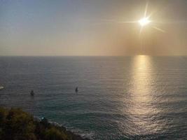 View of the sea and the sun at sunset on vacation in a warm tropical oriental paradise country southern resort photo