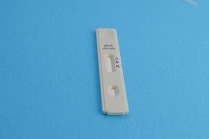 white test strip for the diagnosis of coronavirus infection. test on a blue background. individual kit for the diagnosis of the disease. quick blood test photo