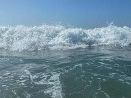 Beautiful sea with waves splashing warm sparkling clear blue water in a warm tropical oriental country southern resort. Background, texture photo