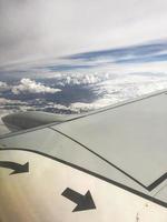 Wing of a beautiful fast jet airplane with an engine in the air at high altitude. Vertical photo