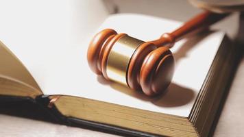 Justice and law concept.Male judge in a courtroom with the gavel, working with, computer and docking keyboard, eyeglasses, on table in morning light video