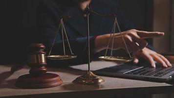 Justice and law concept.Male judge in a courtroom with the gavel, working with, computer and docking keyboard, eyeglasses, on table in morning light video