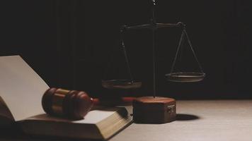 Justice and law concept.Male judge in a courtroom with the gavel, working with, computer and docking keyboard, eyeglasses, on table in morning light video