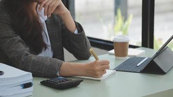 Businesswoman working with smart phone and laptop and digital tablet computer in office with digital marketing media in virtual icon video