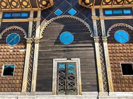 Beautiful vintage ancient old carved authentic door with windows with glass with a forged frame arches and patterns. The background photo