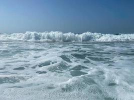 hermoso mar con olas salpicando cálidas y brillantes aguas azules en un cálido resort tropical oriental del sur. fondo, textura foto