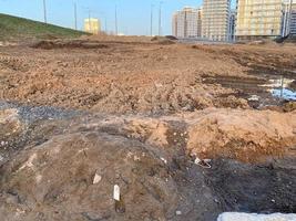 trabajo industrial de construcción en la carretera y tierra marrón excavada con arcilla mientras se pavimenta el asfalto foto