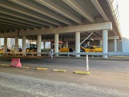 Construction industrial work under the bridge and large highway overpass with the help of modern construction equipment such as asphalt rollers photo