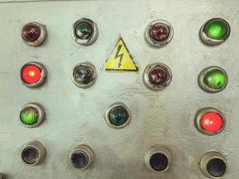 control buttons on the electrical panel. the power indicators glow red or green when energized. remote control panel. buttons indicators on gray painted material photo