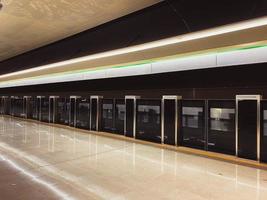 New modern safety screen with sliding doors for the safety of the metro train in the big city on the waiting platform in the metro station at the train station photo