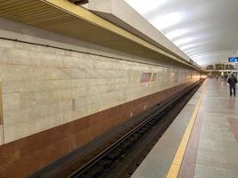 vista del túnel en la plataforma para esperar trenes en la estación de metro con paredes de granito foto