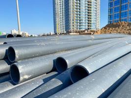 Plastic main black pipes on heap of polyethylene pipes for a water supply system for laying of city communications photo