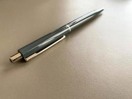 Automatic green ballpoint pen for writing on your desktop office desk. Business work photo