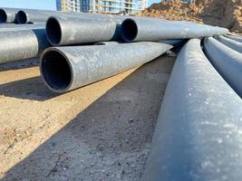 grandes tuberías de plomería de plástico negro industrial de polipropileno moderno de gran diámetro en el sitio de construcción en la colocación de tuberías de agua y la construcción y renovación de edificios y casas foto