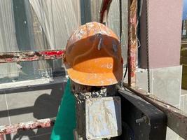 Casco protector de plástico amarillo sucio y rayado del viejo trabajador de la construcción para proteger la cabeza de objetos que caen en el sitio de construcción foto