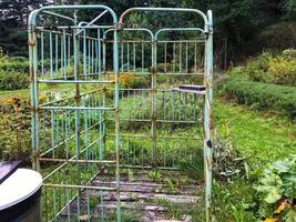 rusty headboards from old beds. homemade shower cabin from scrap materials. rusty, corroded backs. handmade. shower cabin for summer cottages, no hot water photo