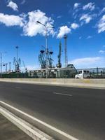 Industrial shipyard for ships in the port with large iron cranes for loading and unloading cargoes near the road photo