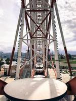 Metallic white iron construction of pipes, the mechanism of the Ferris wheel is not against the backdrop of the mountains. Inside view photo