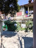 calle estrecha, carril, túnel con casas antiguas, edificios a los lados en una zona pobre de la ciudad, barrios marginales. foto vertical