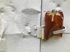 metallic texture in silvery color. a plastic brown cropped bottle is inserted in the texture. texture with peeling paint, damage, holes, corrosion and rust photo