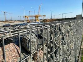 Iron metal mesh reinforcement on a concrete wall in the construction of houses by industrial methods with the help of cranes photo