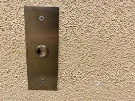 Large iron metal chrome plated modern new elevator call button on the background of the porch wall photo