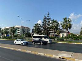 Cars and beautiful modern buildings, architecture, road and palm trees in a warm tropical eastern country southern resort photo