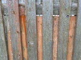 textura superficial de una antigua valla zoonótica de madera gris hecha de tablones verticales. el fondo foto