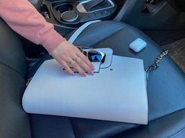 hermosa bolsa de cuero de moda femenina blanca y gafas de sol con auriculares inalámbricos y mano femenina en el camión foto