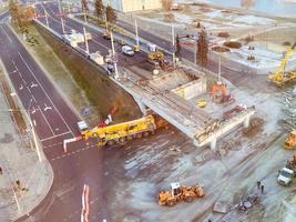 view from a height of a large construction site. construction of a bridge in the city center. construction of a new overpass on a fenced section of the road photo