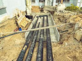 black, polypropylene, long pipes are laid underground for communications. underground communications with water for residential buildings photo