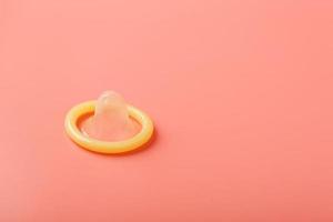 Condom on a pink background, close-up, top view. photo